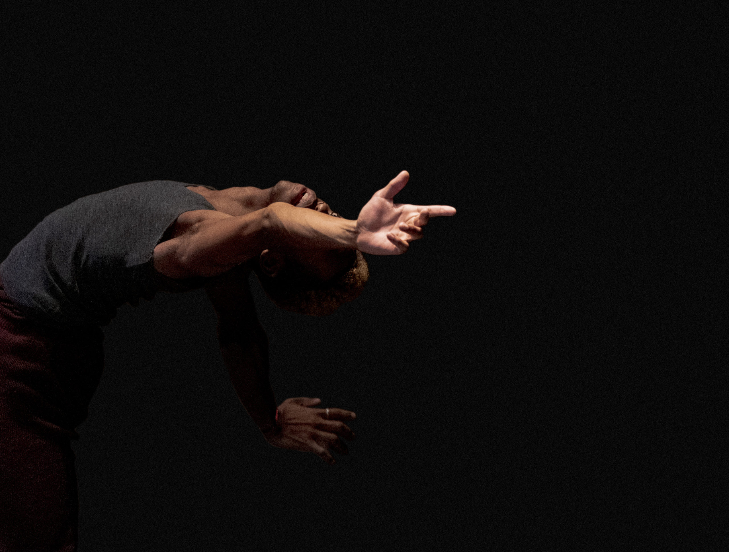 A young artist in a cambre back, reaching behind him