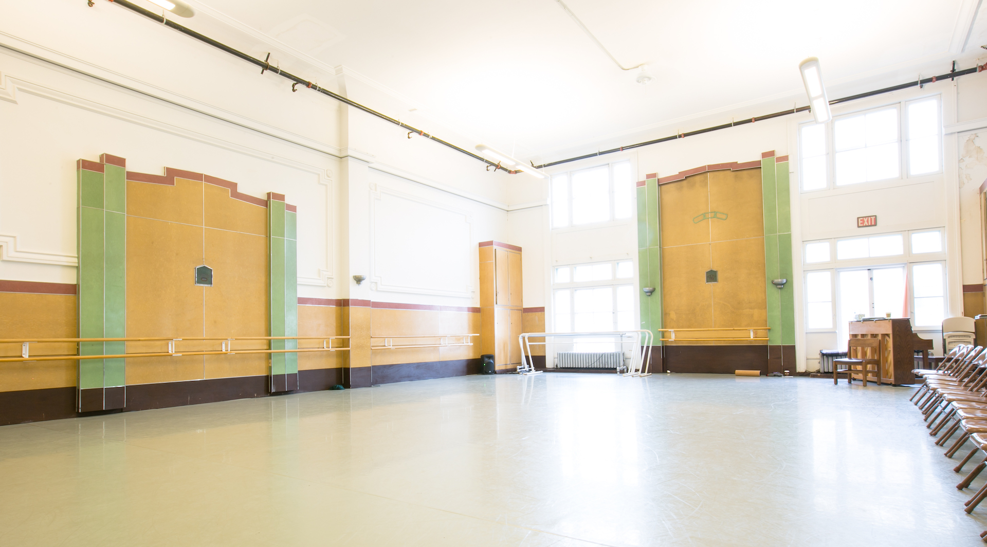 A large, empty dance studio with floor-to-ceiling windows