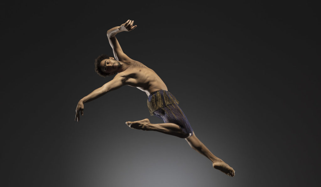LINES Ballet company artist Michael Montgomery suspended in a jump in the air in front of greyish white background