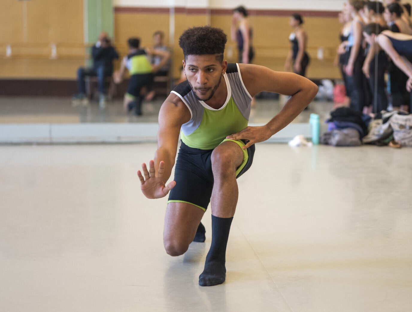 Former LINES Summer Program student dancing in a workshop led by Alonzo King, other students standing to the side observing at LINES Dance Center