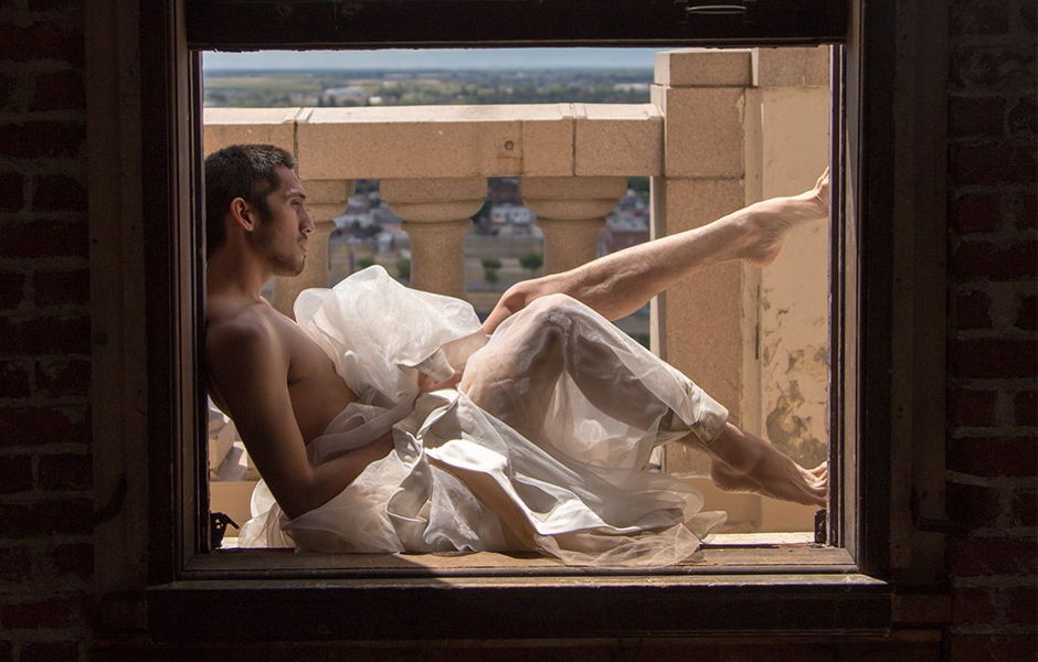 Modern Dance Teacher Elijah Muñoz, posing in a window.