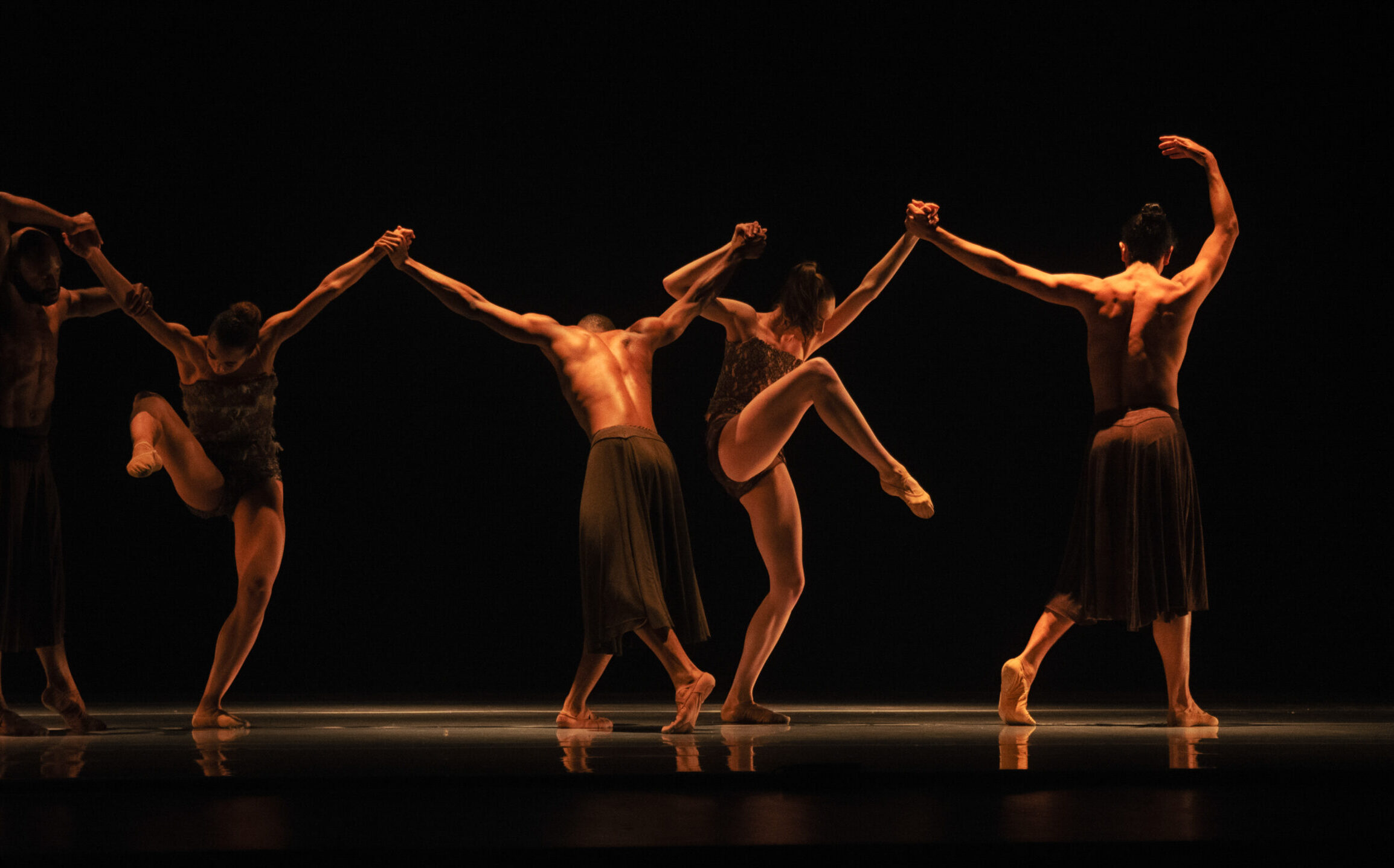 LINES Ballet company dancers performing in Alonzo King's "Deep River" on stage; dancers are moving together while holding hands in a line