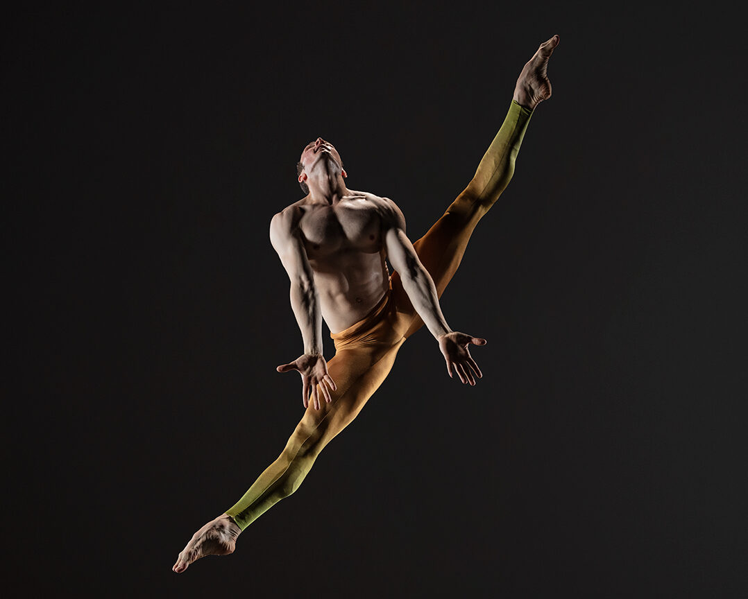 LINES Ballet Company Dancer Theo Duff-Grant jumping with legs in a side split and head arched back