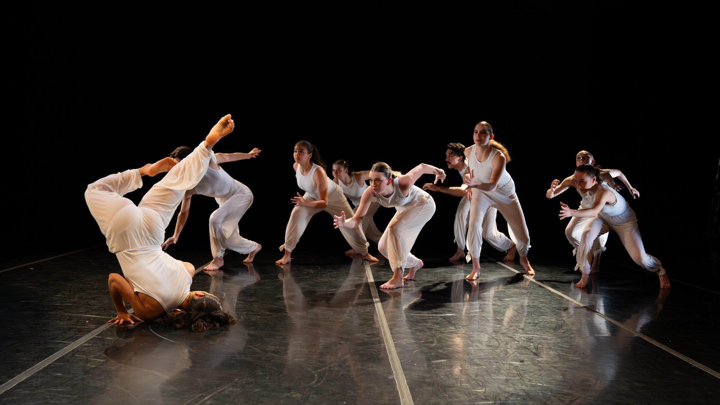 LINES Ballet Training Program students performing a work on stage choreographed by Moscelyne ParkeHarrison while wearing white