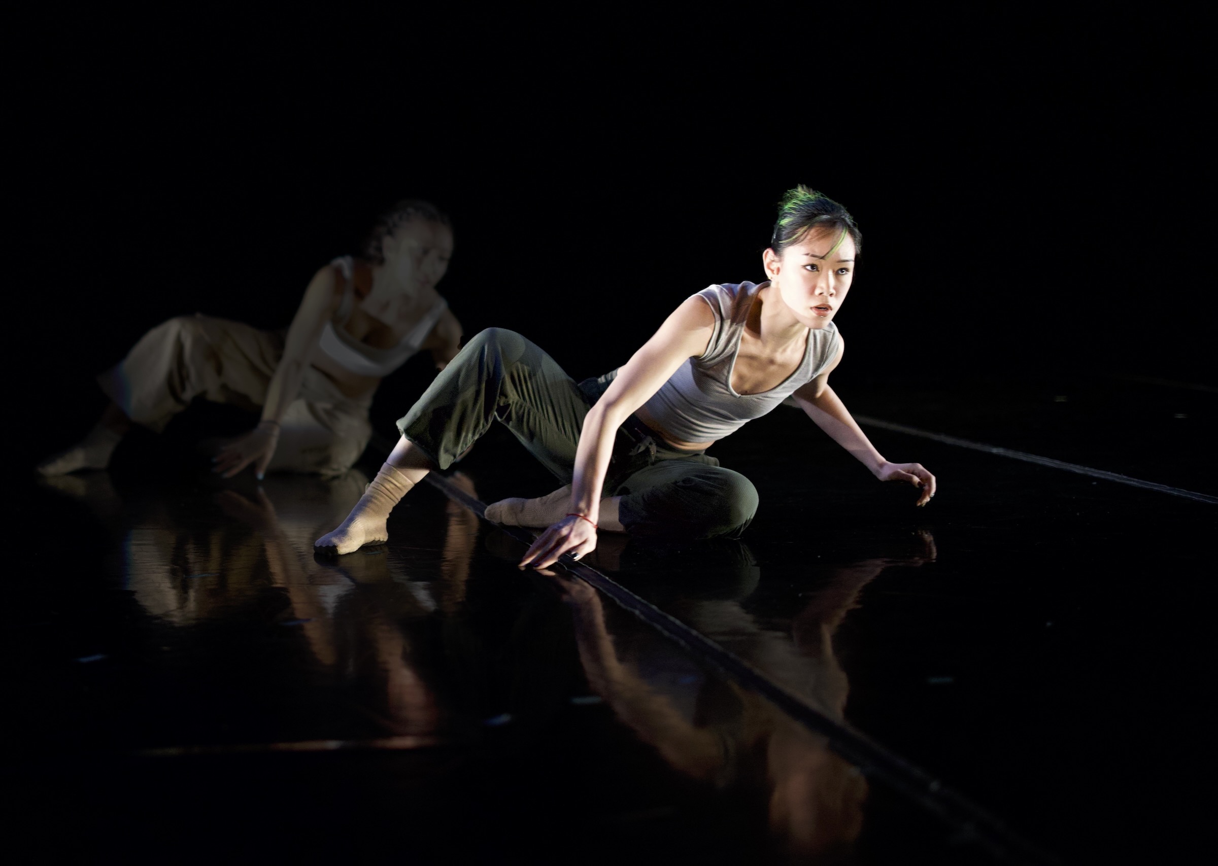 Two dancers perform onstage in neutral tones a work by Alejandro Perez.