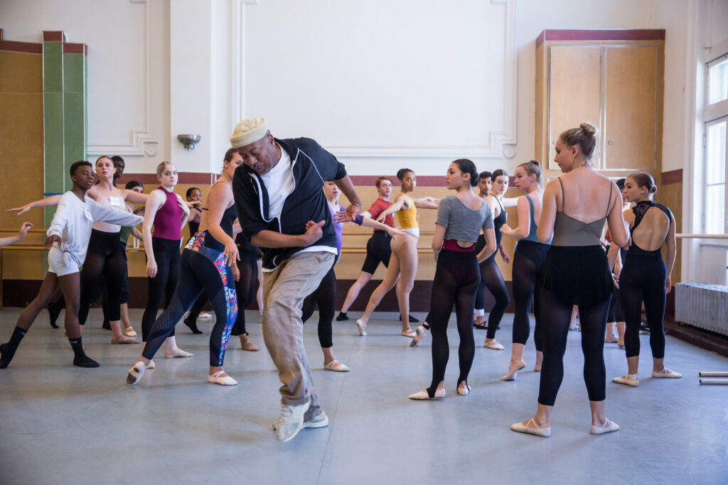 Alonzo King demonstrating a dance step for young students in a dance studio