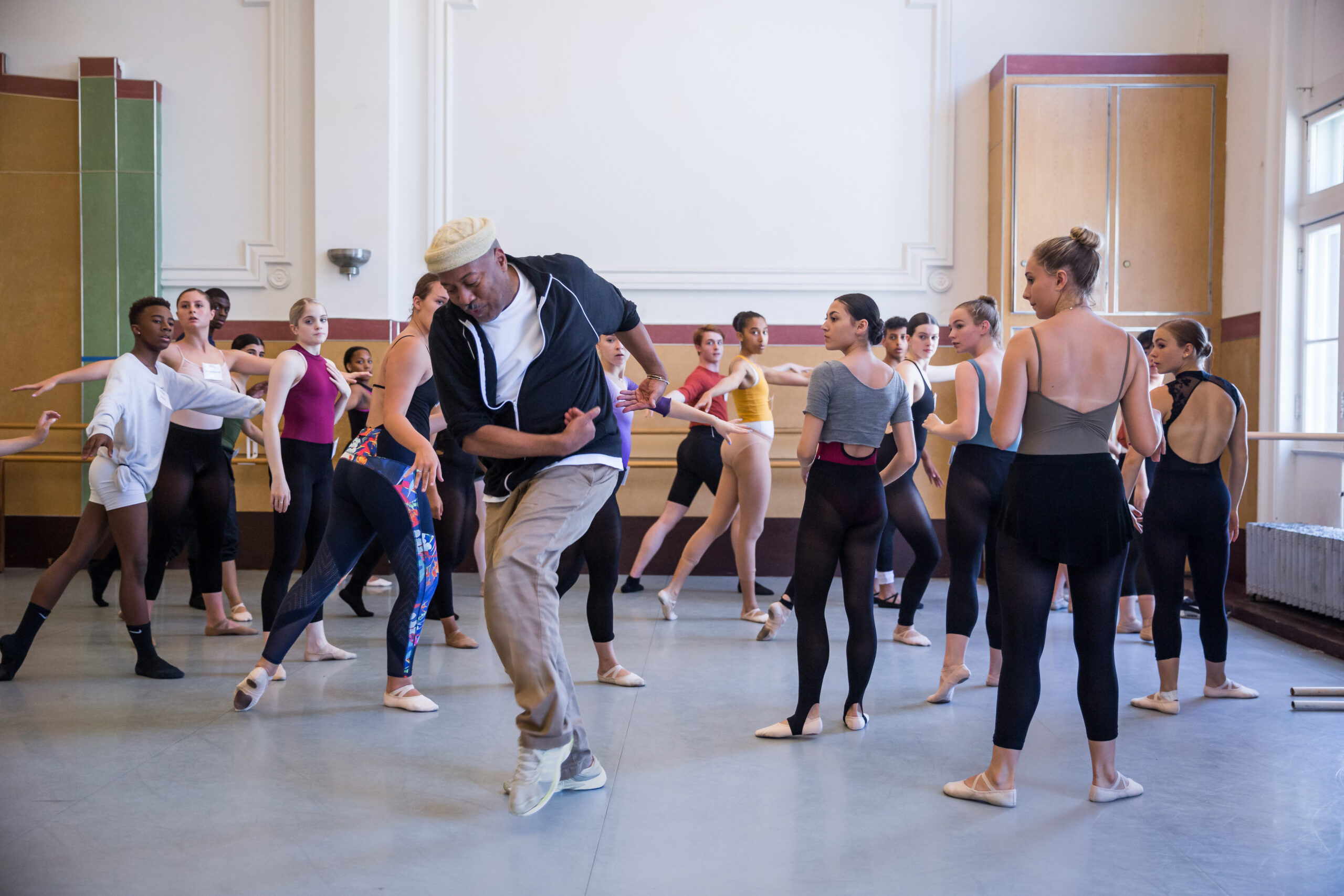 Alonzo King demonstrating a dance step for young students in a dance studio