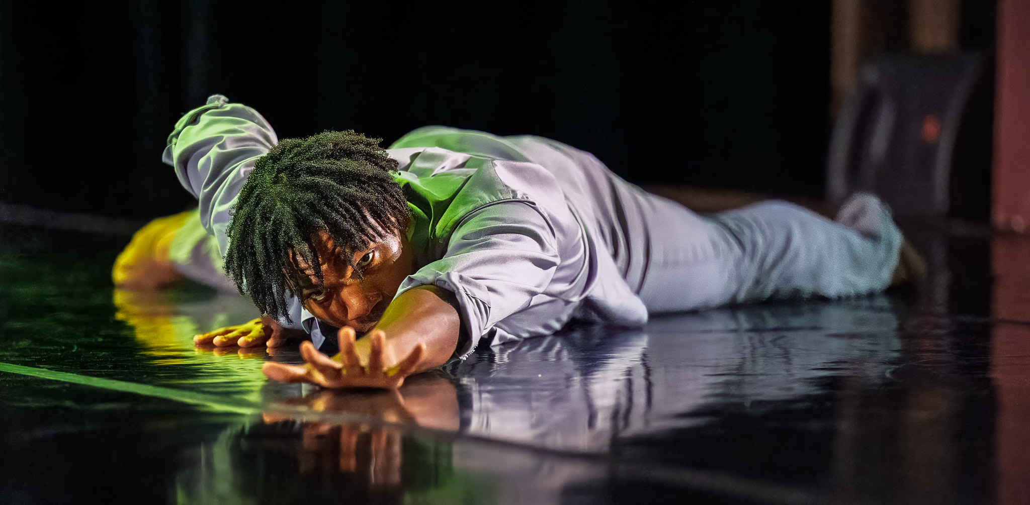 LINES BFA dancer lies on their stomach reaching forward towards the camera