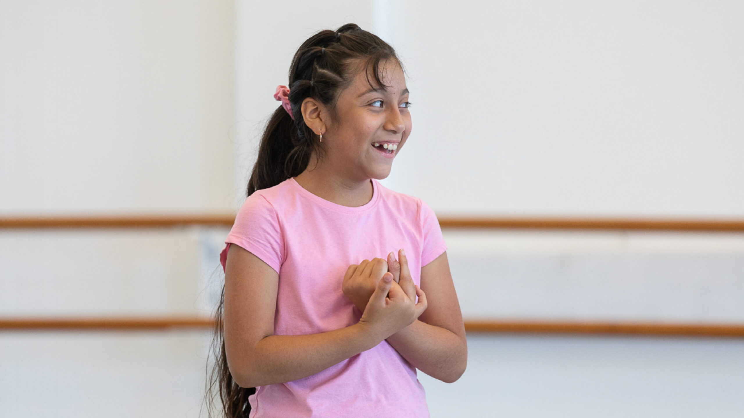 One child clasps their hands with a joyous smile.